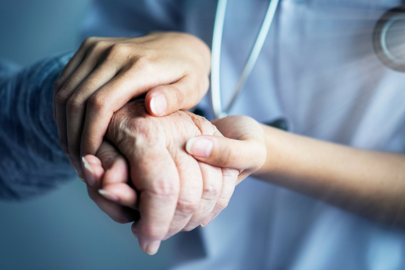 A compassionate doctor gently holds the hand of an elderly patient