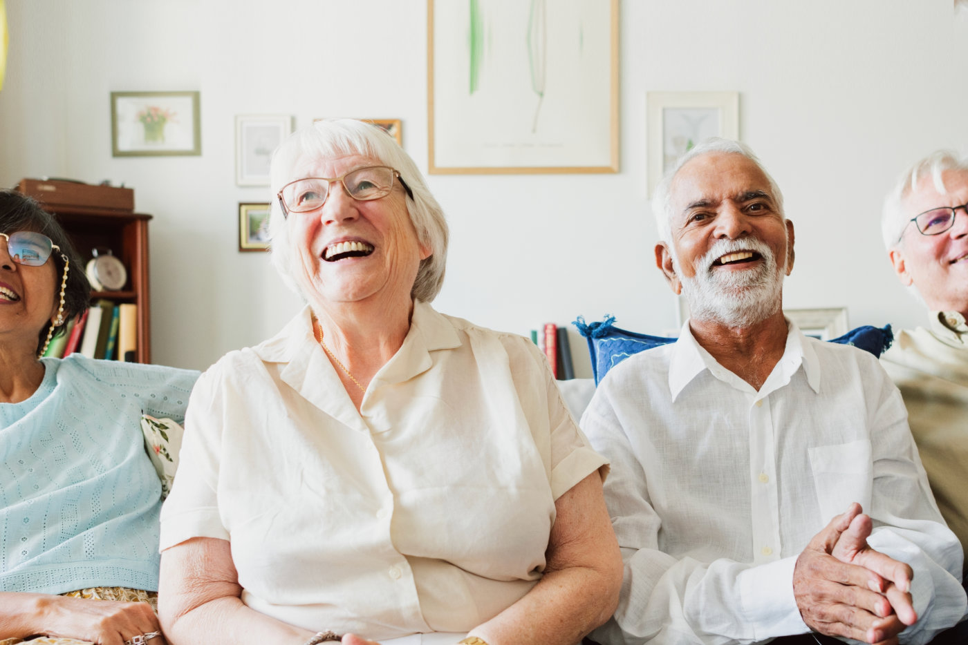 Group of four elderly people sitting on a couch