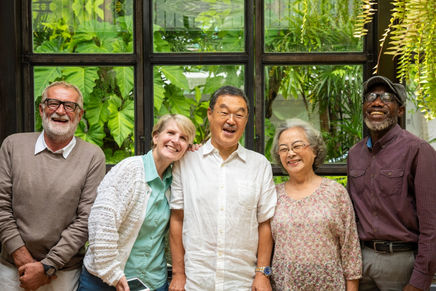 Group of five diverse seniors smiling.
