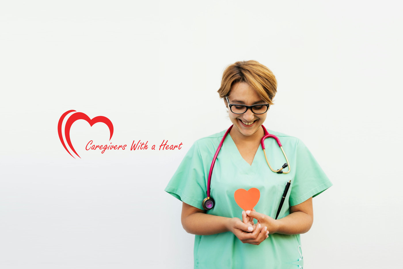 A healthcare professional in scrubs is holding a heart-shaped object, representing love and dedication to patient care.